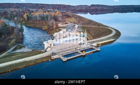 Michigan dam on smooth lake leading to river in late fall forest Stock Photo