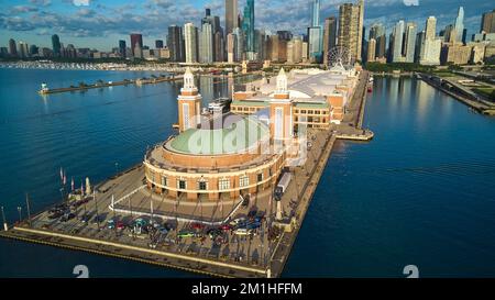 Aerial over end of Navy Pier during vintage car show with view of Chicago downtown skyline Stock Photo
