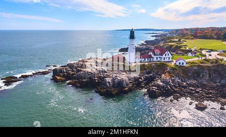 Aerial view of a lighthouse on a rocky cliff overlooking the ocean ...