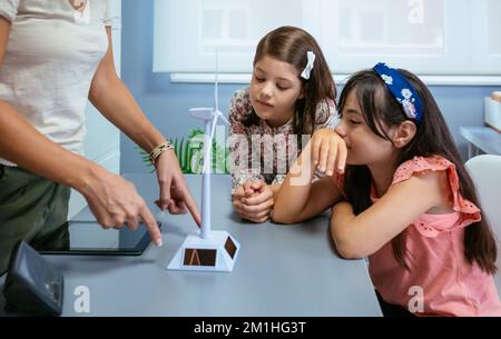 Students looking solar windmill while teacher explaining in ecology classroom Stock Photo