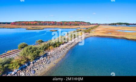 Empty train track bridge crosses through marshes in Maine Stock Photo