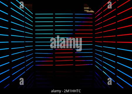 Empty dark room lined with red and blue LED horizontal poles of light Stock Photo