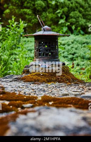 Small metal lantern in zen garden on rocks and moss for Tibetan Mongolian Buddhist  Stock Photo