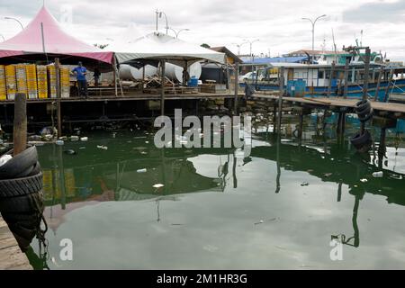 Discarded plastic bottles pollute the harbour and threaten the local fishing industry in Kudat, Borneo, Malaysia. Stock Photo