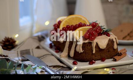 Christmas home made cinnamon cake with fruits and spekulatius cookies cream by the window on a winter interior scene. Stock Photo