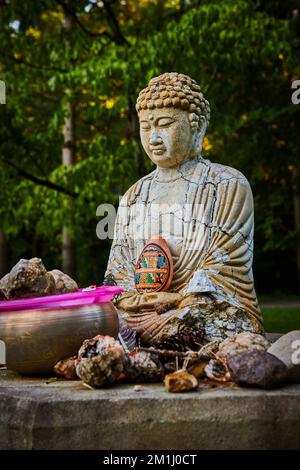 Tibetan Mongolian Buddhist small statue with cracks at shrine for donation and prayer Stock Photo