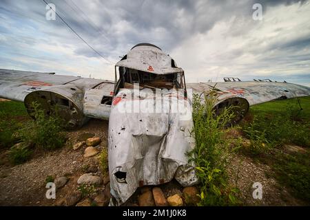 Front view of crashed airplane small in fields with overcast sky Stock Photo