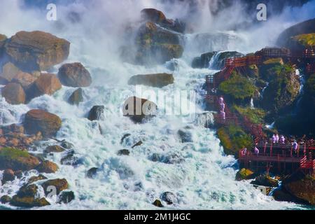 Detail of American Niagara Falls with mist covering tourists on red stairs Stock Photo