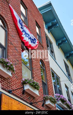 American red, white, and blue banner on brick wall of shop Stock Photo