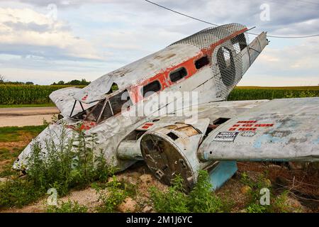 Side view of abandoned destroyed airplane resting in field Stock Photo