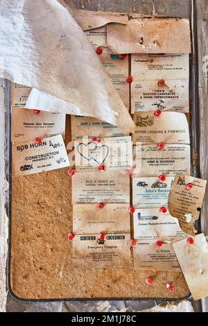 Abandoned cork board covered with old business cards pinned Stock Photo