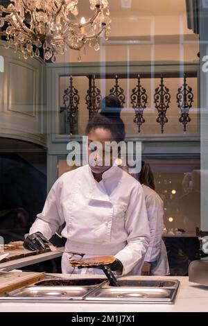 Amsterdam Netherlands December 2020, woman making a Stroopwafel in an Amsterdam shop a typical Dutch food two circular pieces of waffle filled with a caramel syrup Stock Photo