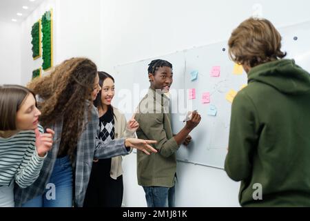 Creative business team reading the sticky notes and discussing. Stock Photo