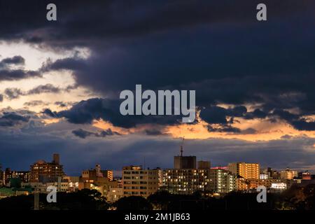 Dramatic storm clouds over apartments and office buildings at sunset Stock Photo