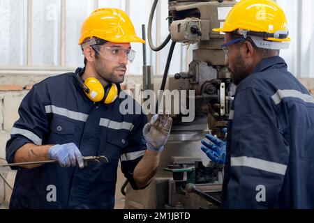 Engineer man training with foreman for apprentice using lathe, apprenticeship teaching with worker, technician and learning, inspector and labor, inte Stock Photo