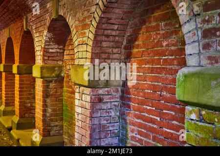 Brick wall with faded white and moss and arches in Central Park New York City Stock Photo