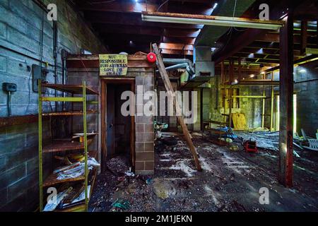 Interior abandoned mechanic shop with rubble and destroyed bathroom Stock Photo