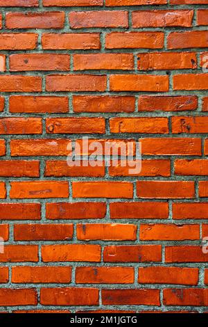 Vertical vibrant orange brick wall straight on texture with dark gray mortar Stock Photo