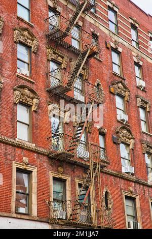 Looking up old red brick apartment building in New York City with stairs zig zagging up side Stock Photo