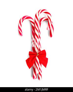 Sweet candy canes with Christmas bow isolated on white background Stock Photo
