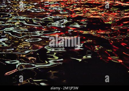 Night river with blue and red lights on highlights of waves Stock Photo