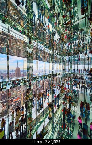 Huge skyscraper interior mirror reflections Summit One with New York City skyline and Empire State Building outside Stock Photo