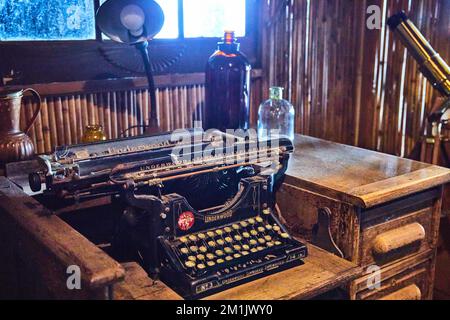 Still life scene of old typewriter on old wood desk with antique objects like bottles around Stock Photo
