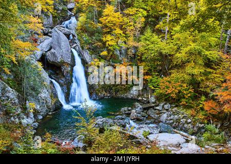 Magical blue waterfall in New York fall with yellow foliage Stock Photo