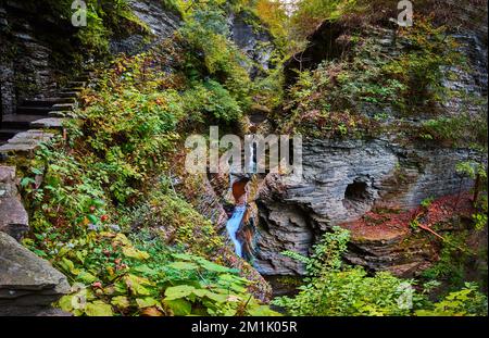 Wide view of trail along winding gorge with river, waterfalls, and layered rocks Stock Photo