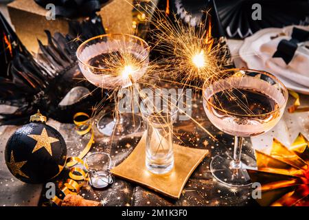 Happy New Year - two glasses of champagne with sparkler on decorated festive table Stock Photo