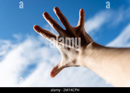 Hand of a man reaching to towards sky. Stock Photo