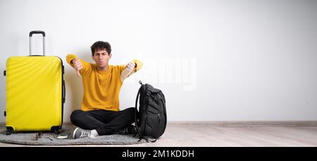 Arabic man traveler with suitcase looking unhappy and angry showing rejection and negative with thumbs down gesture. bad expression. Copy space Stock Photo