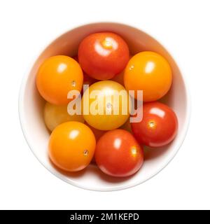 Colorful cherry tomatoes in a white bowl. Fresh, ripe type of small and round cocktail tomatoes, of red, yellow and orange color. Stock Photo