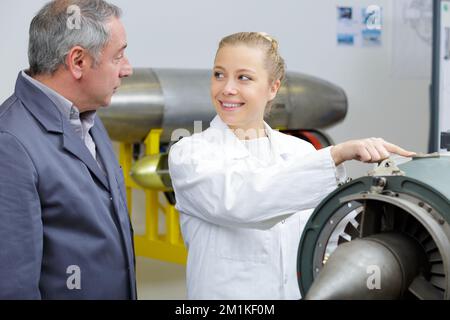 aero engineer and apprentice working in hangar Stock Photo
