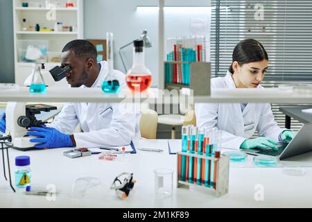 Portrait of two ethnic scientists working in laboratory and doing medical research Stock Photo