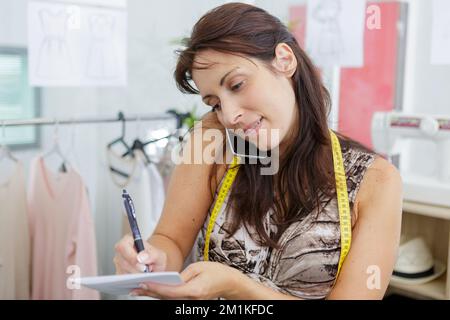 seamstress woman using her smartphone Stock Photo