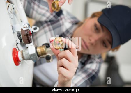 female technician lining up a threaded adapter Stock Photo