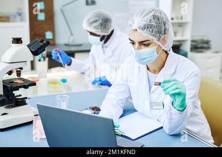 Portrait of young Middle Eastern woman working in modern laboratory and doing blood tests Stock Photo