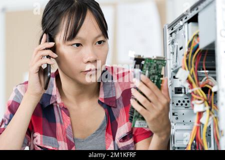female computer technician engineer speaks on the phone Stock Photo