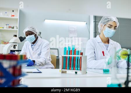 Medical laboratory with two workers and colored test tubes Stock Photo