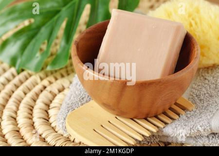 Solid shampoo soap bar in wooden bowl with comb - Concept of beauty product and ecology Stock Photo