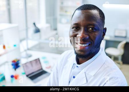 Close up portrait of smiling black man looking at camera in medical laboratory, copy space Stock Photo