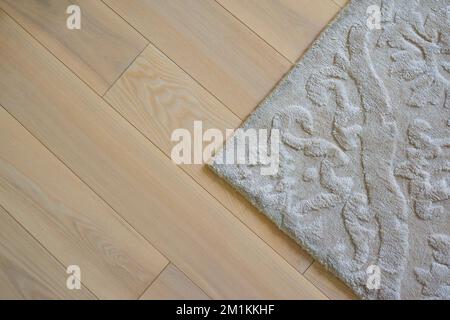 Laminate parquete floor, with soft carpet. interior design. Wooden floor background Stock Photo