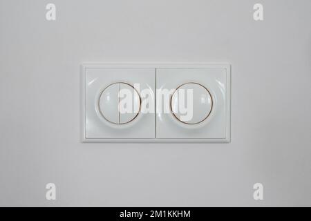 White switch on white wall. Regulator of electric switch of candle-power Stock Photo