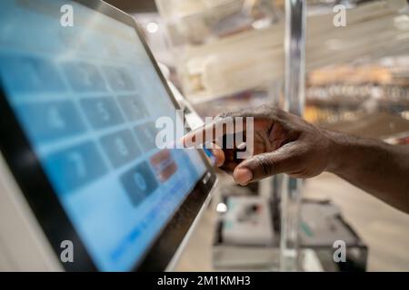 Close up picture of a screen and mans hand touching buttons Stock Photo