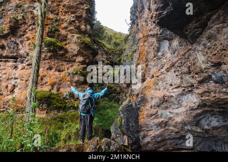 Rear view of a hiker at Mau Mau caves in Chogoria Route, Mount Kenya National Park, Kenya Stock Photo