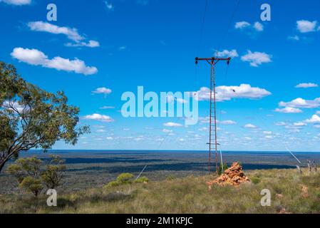 An electricity power pole and powerlines that supply light and power to the top of Mount Oxley in outback New South Wales, Australia near Bourke Stock Photo