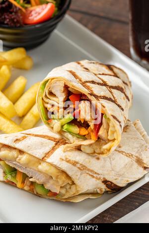 Chicken wrap with french fries and salad Stock Photo