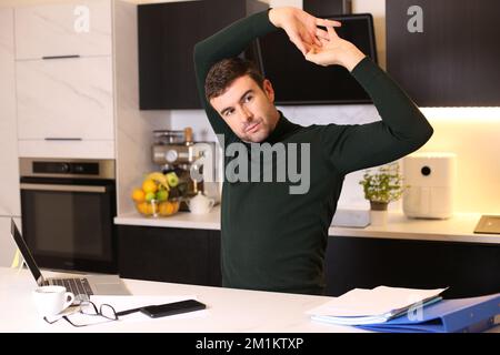 Man stretching in home office Stock Photo