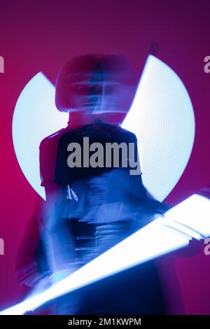 long exposure of blurred woman with vibrant neon lamps on purple background,stock image Stock Photo